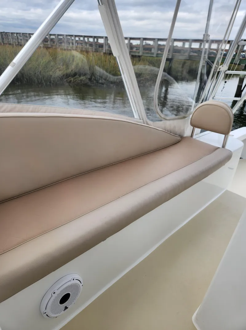 Slide: The Image of 1996 Jersey Devil boat interior with beige seating and water view. - 16
