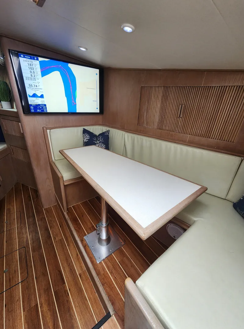 Slide: The Image of Cozy boat interior with seating, table, and navigation screen, Jersey Devil 1996 model. - 19