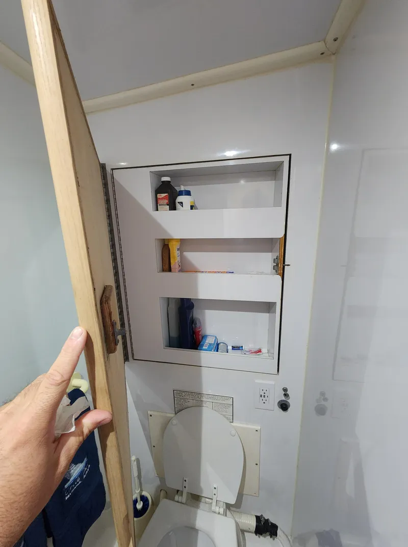 Slide: The Image of Compact bathroom cabinet with open door, revealing shelves with toiletries. Jersey Devil 1996 model. - 26