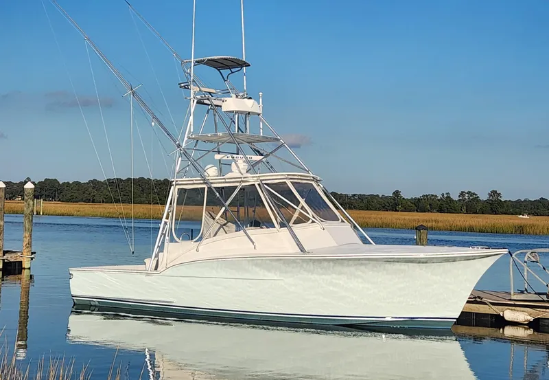 Slide: The Image of 1996 Jersey Devil boat docked on calm water under clear blue sky. - 3