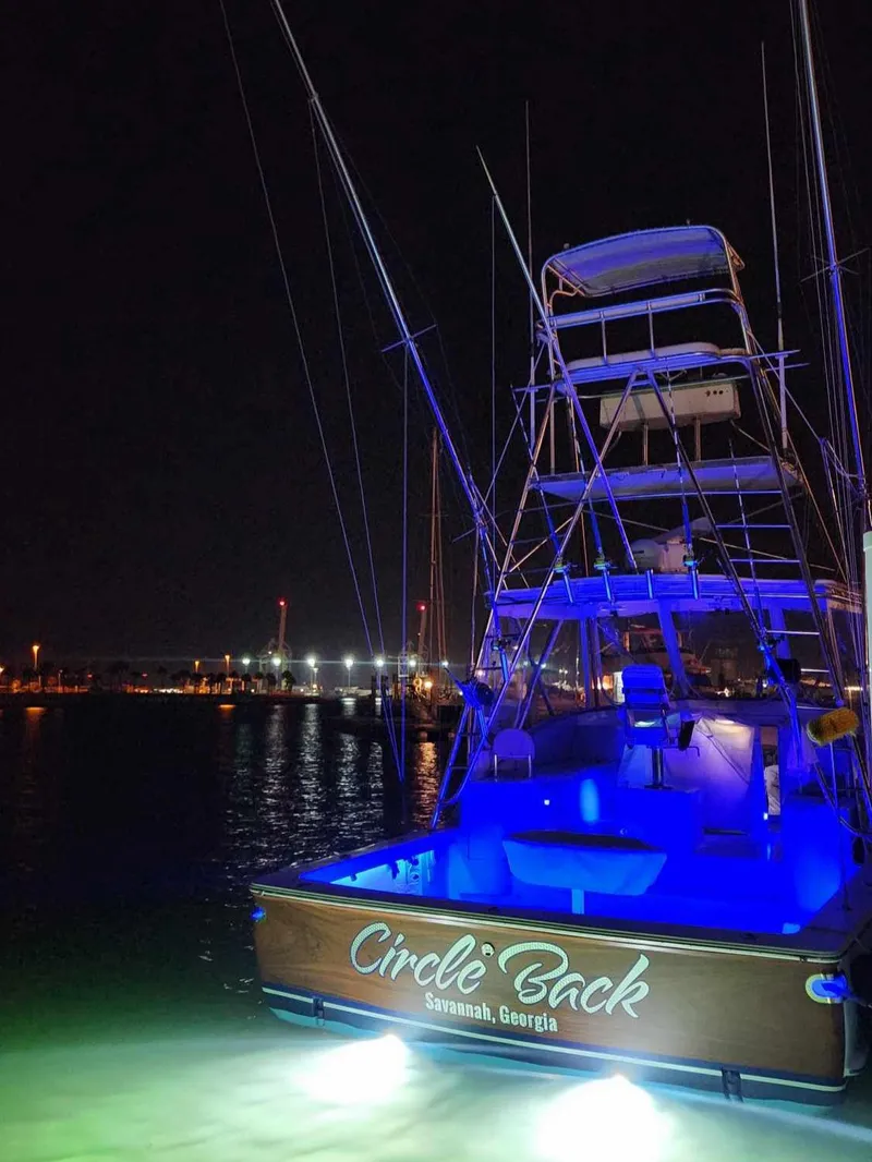 Slide: The Image of Fishing boat "Circle Back" docked at night, illuminated by blue lights. - 5