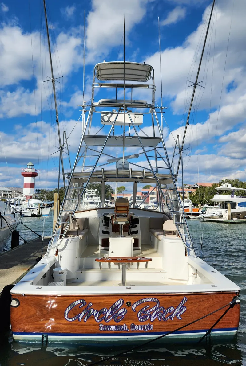 Slide: The Image of Sport fishing boat docked at marina, featuring a tall tower and clear skies. - 6