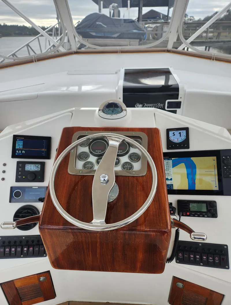 Slide: The Image of 1996 Jersey Devil boat helm with wooden steering wheel and navigation instruments. - 8