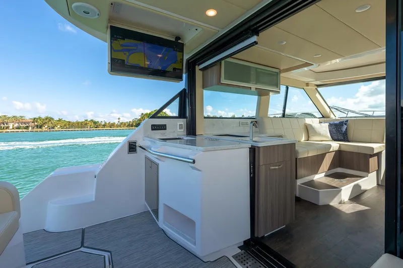 Slide: The Image of 2026 Regal 38 XO boat storage compartment with open hatch, dockside view. - 10