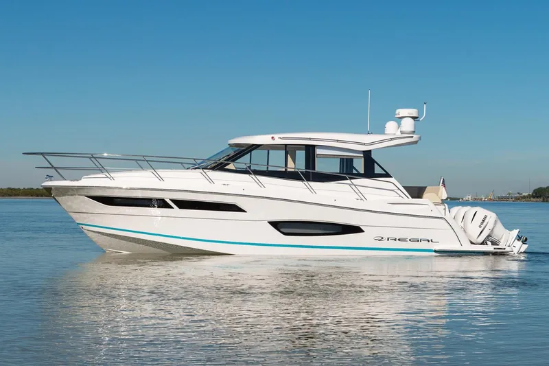 Slide: The Image of 2026 Regal 38 XO yacht docked at marina under clear blue sky. - 2