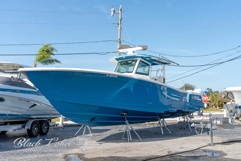 The Image of 2021 Caymas 401 CC boat in vibrant blue on display outdoors. - 0