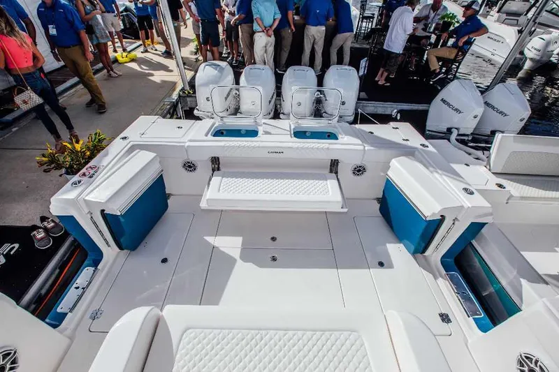 Slide: The Image of 2021 Caymas 401 CC boat interior with seating and outboard motors at a dock. - 13