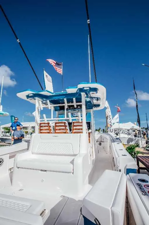 Slide: The Image of 2021 Caymas 401 CC boat with American flag, showcased under clear blue sky. - 14