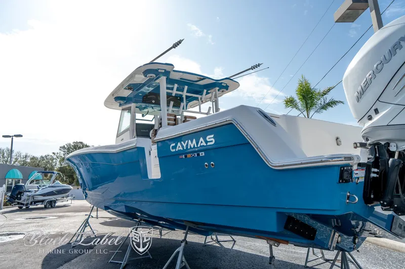 Slide: The Image of 2021 Caymas 401 CC boat in vibrant blue, displayed outdoors with Mercury engines. - 2