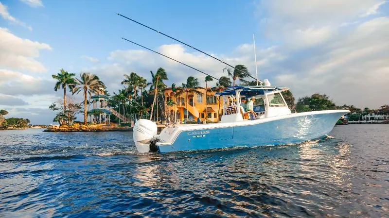 Slide: The Image of 2021 Caymas 401 CC boat cruising near waterfront homes and palm trees. - 21