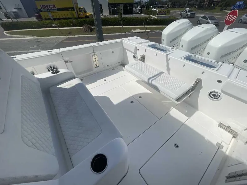 Slide: The Image of 2021 Caymas 401 CC boat interior with white seating and multiple outboard engines. - 24