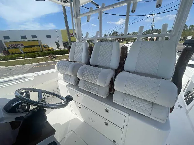 Slide: The Image of 2021 Caymas 401 CC boat interior with white quilted seats and steering wheel. - 28