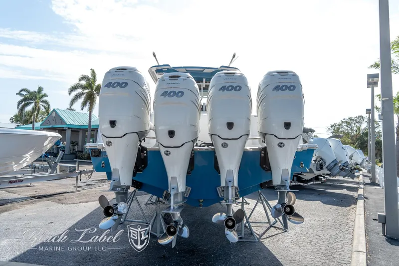 Slide: The Image of 2021 Caymas 401 CC boat with four powerful outboard engines, parked outdoors. - 3