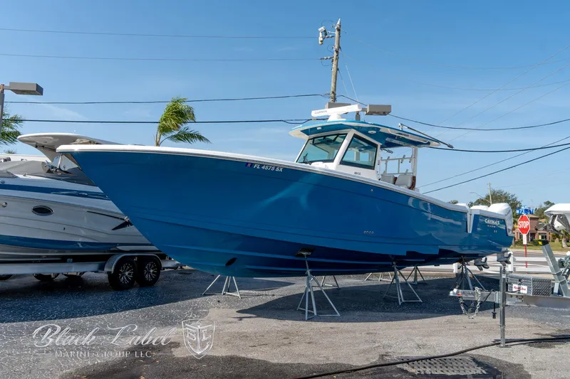 Slide: The Image of 2021 Caymas 401 CC boat in blue, displayed on stands at a marina. - 5