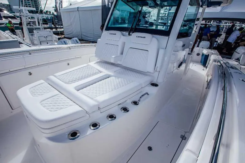Slide: The Image of 2021 Caymas 401 CC boat interior with white cushioned seating and rod holders. - 7