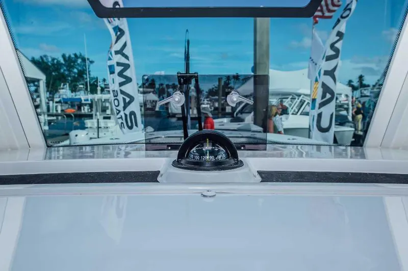 Slide: The Image of Caymas 401 CC 2021 boat interior with compass and marina view. - 9