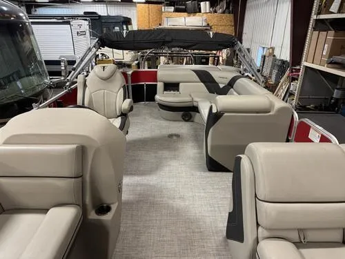 Slide: The Image of 2022 Forest River Trifecta pontoon boat interior with beige seating and black accents. - 6