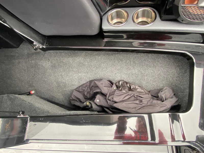 Slide: The Image of Interior storage compartment of 2022 MasterCraft XT24 boat with cup holders. - 26