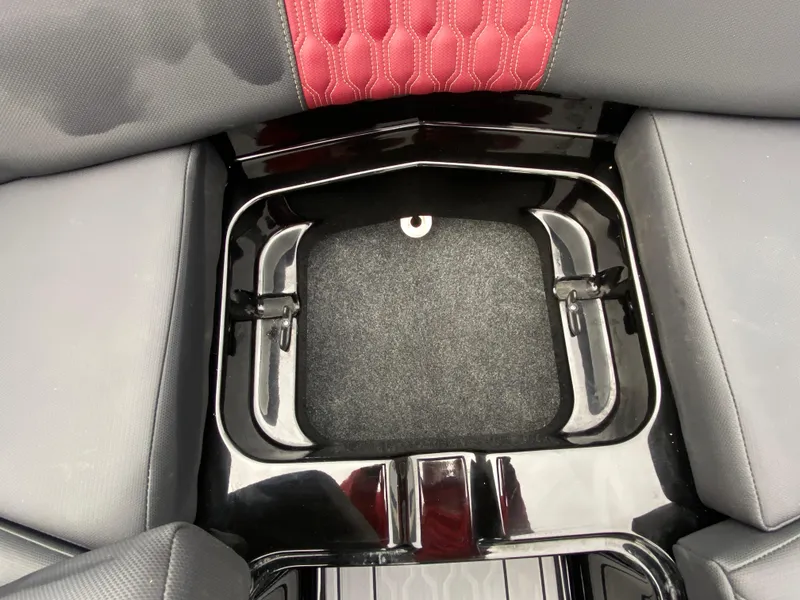Slide: The Image of 2022 MasterCraft XT24 boat interior storage compartment with red and gray seating. - 27