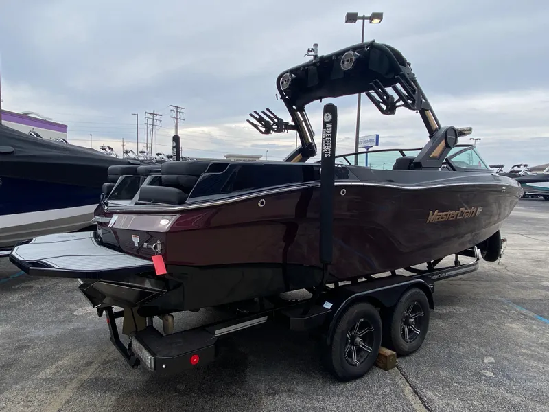 Slide: The Image of 2022 MasterCraft XT24 boat on trailer, parked outdoors. - 4