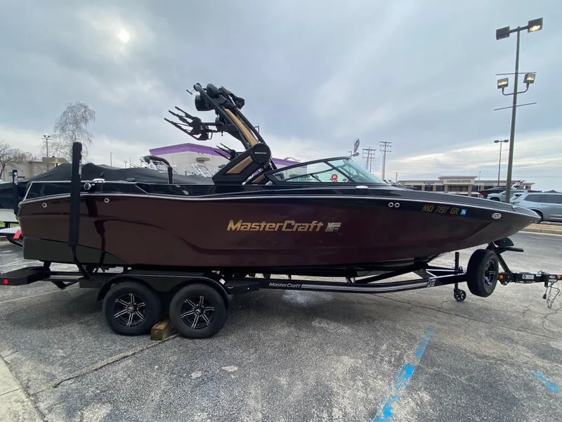 Slide: The Image of 2022 MasterCraft XT24 boat on trailer in parking lot. - 5