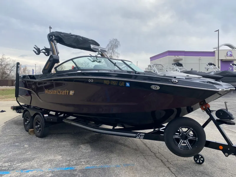 Slide: The Image of 2022 MasterCraft XT24 boat on trailer, parked outdoors. - 6