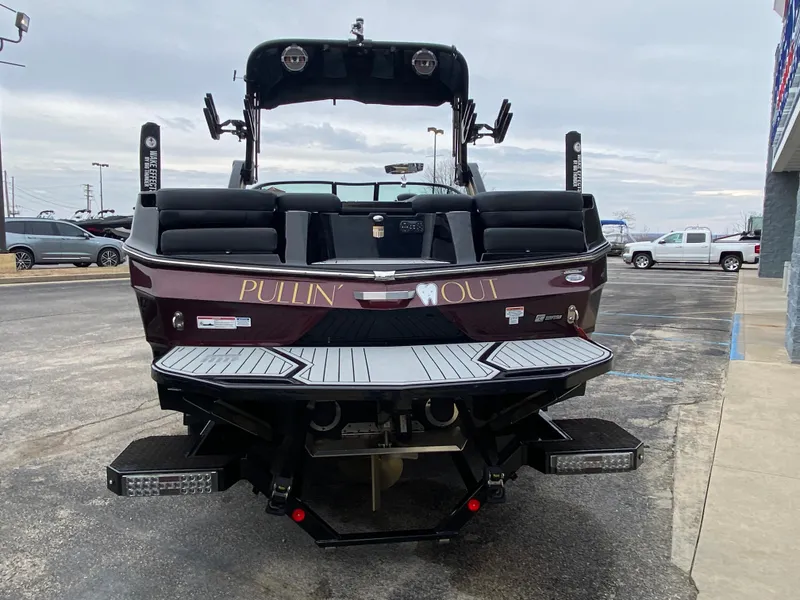 Slide: The Image of 2022 MasterCraft XT24 boat, rear view, parked outdoors. - 7