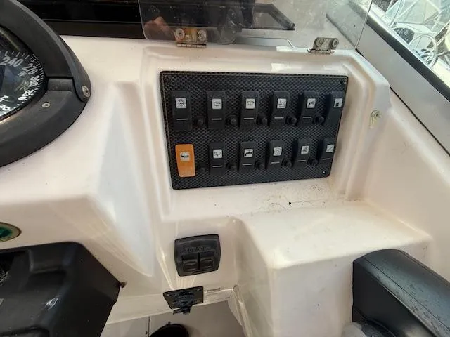 Slide: The Image of Control panel of 2002 Grady-White 232 Gulfstream boat with switches and compass. - 13