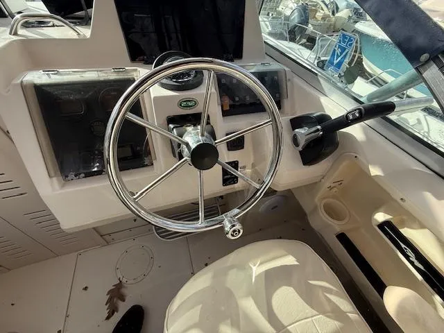 Slide: The Image of 2002 Grady-White 232 Gulfstream boat helm with steering wheel and controls. - 14