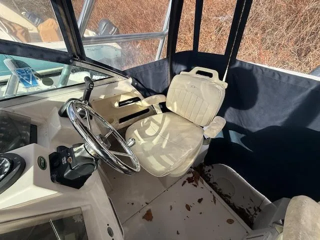 Slide: The Image of Interior of 2002 Grady-White 232 Gulfstream boat with steering wheel and captain's chair. - 16