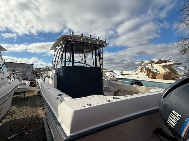 Slide: The Image of 2002 Grady-White 232 Gulfstream boat with Yamaha engine, docked under cloudy sky. - 5