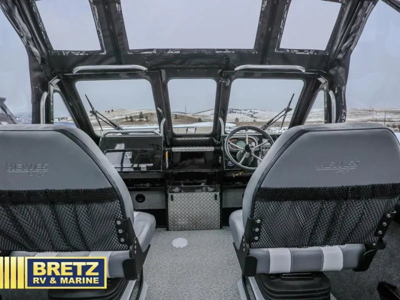 Slide: The Image of Interior view of 2025 River Runner 180 boat cockpit with dual seats and panoramic windows. - 13