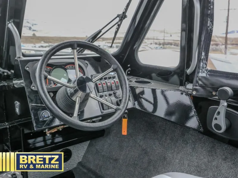 Slide: The Image of 2025 River Runner 180 boat dashboard with steering wheel and control panel. - 14