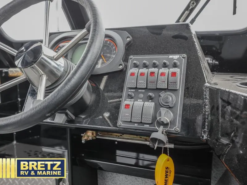 Slide: The Image of Control panel of 2025 River Runner 180 boat with steering wheel and switches. - 15