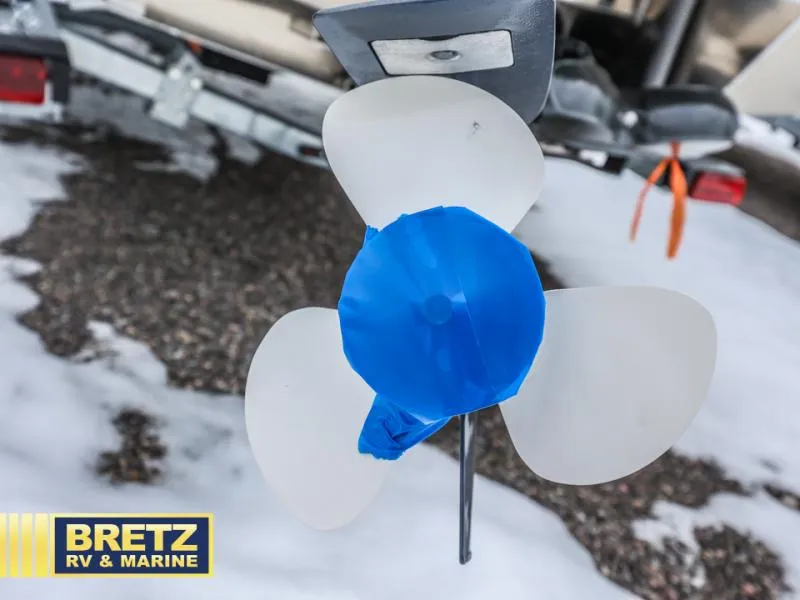 Slide: The Image of Propeller of 2025 River Runner 180 boat, covered with blue tape, on snowy ground. - 8