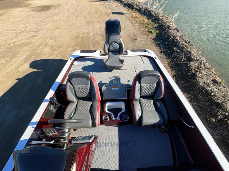 Slide: The Image of 2023 Caymas CX 18 SS boat interior with seating and console, docked by a lake. - 4