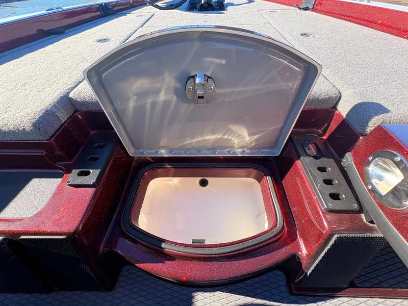 Slide: The Image of 2023 Caymas CX 18 SS boat storage compartment with open lid, red and gray interior. - 5