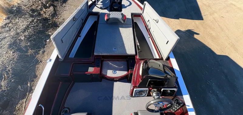 Slide: The Image of 2023 Caymas CX 18 SS boat interior with open storage compartments and steering console. - 7
