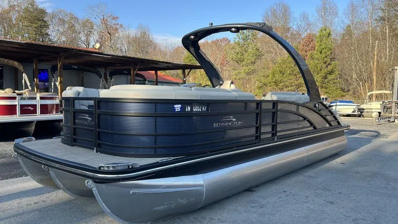 Slide: The Image of 2020 Bennington 23 RCW pontoon boat with sleek black design, parked outdoors. - 3