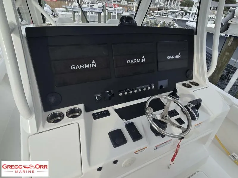 Slide: The Image of 2024 Regulator 37 boat dashboard with Garmin displays and steering wheel. - 10