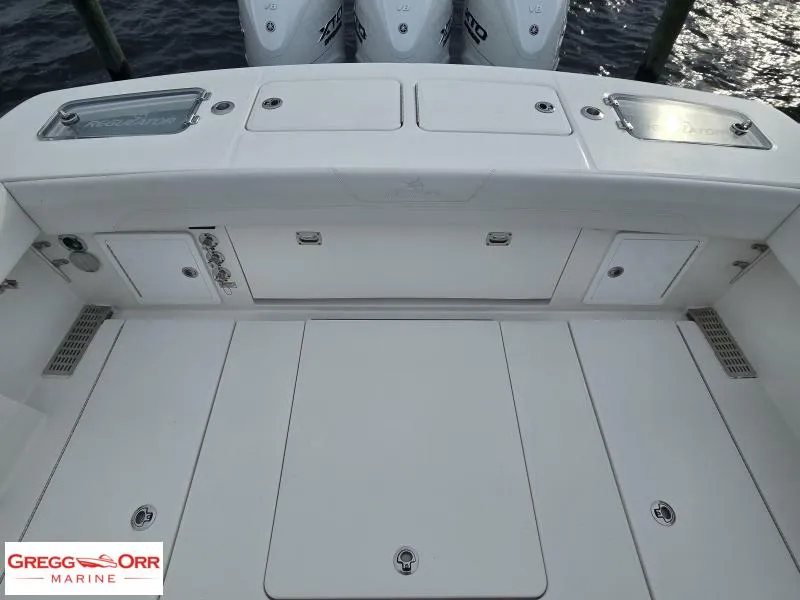 Slide: The Image of 2024 Regulator 37 boat deck with storage compartments and triple outboard engines. - 15