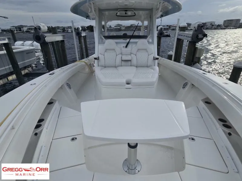 Slide: The Image of 2024 Regulator 37 boat interior with seating and table, docked at marina. - 3