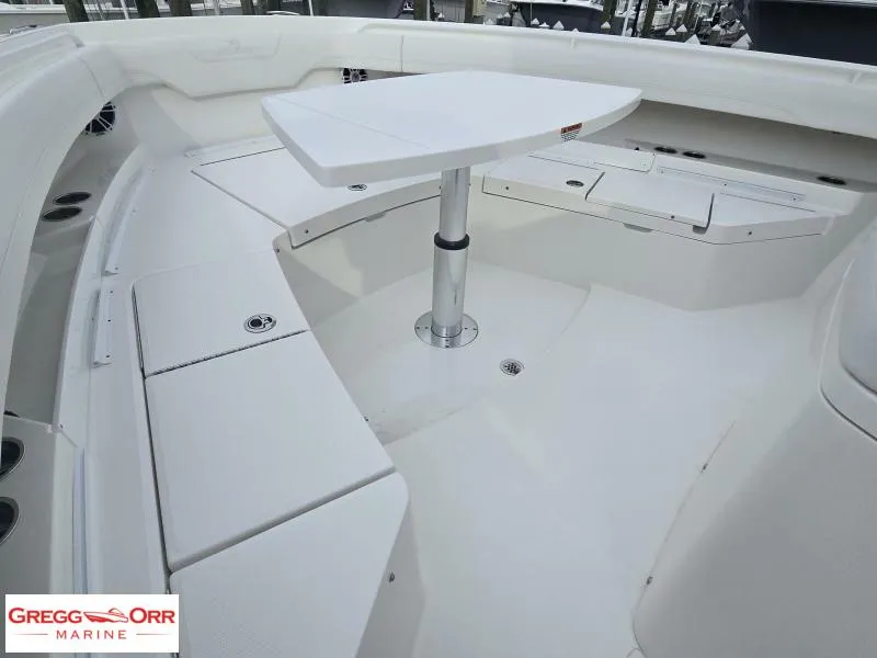 Slide: The Image of 2024 Regulator 37 boat interior with seating and table, showcased by Gregg Orr Marine. - 5