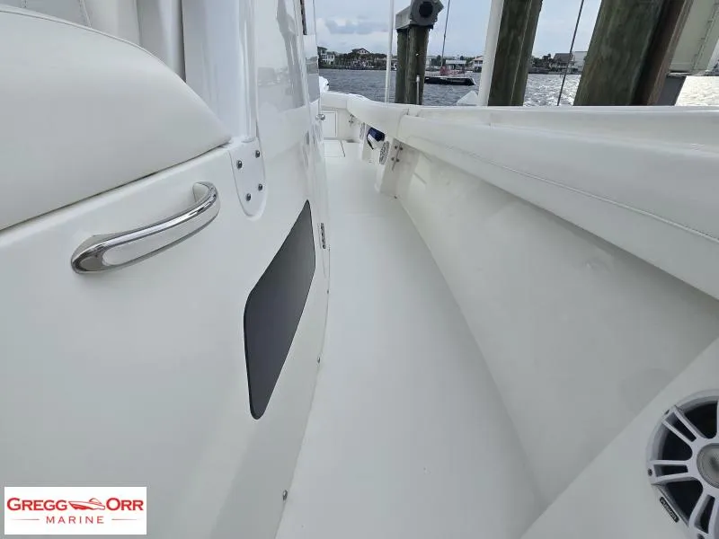 Slide: The Image of 2024 Regulator 37 boat deck view at dock, featuring sleek white design. - 6