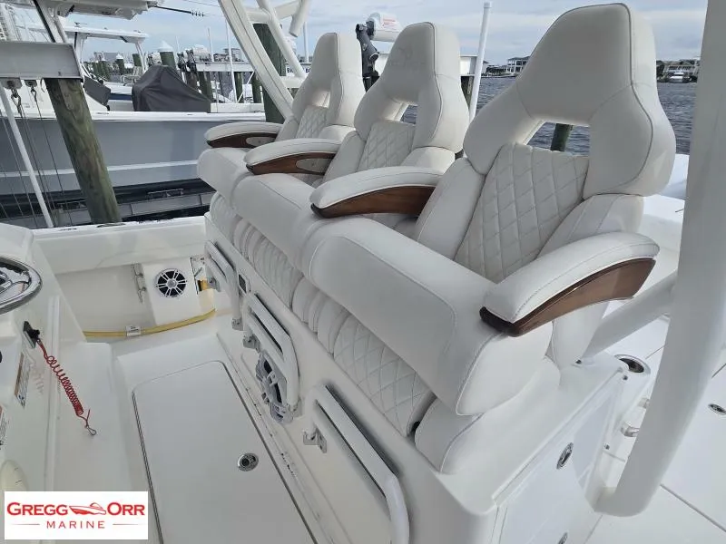 Slide: The Image of 2024 Regulator 37 boat with luxurious white seating and wooden armrests at Gregg Orr Marine. - 7