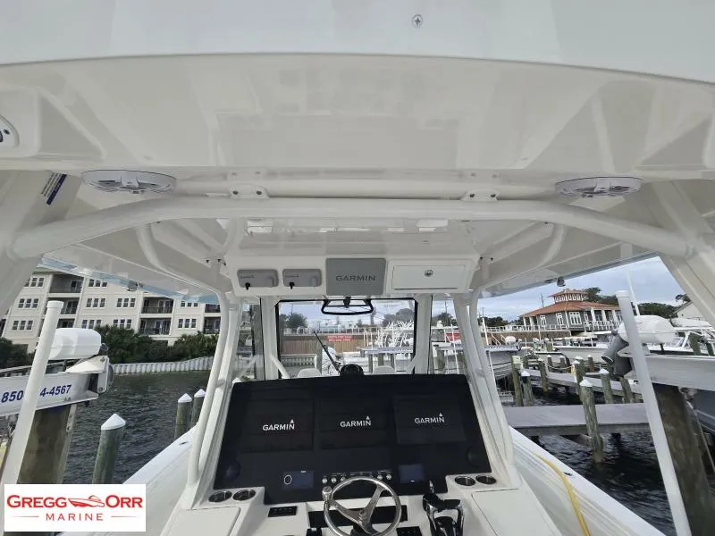 Slide: The Image of 2024 Regulator 37 boat helm with Garmin displays at a marina. - 8