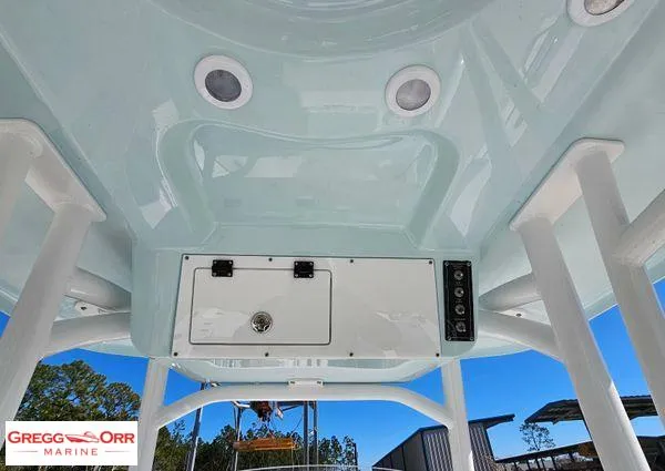 Slide: The Image of 2024 Sea Pro 222 CC boat console with storage and controls, under a clear blue sky. - 16