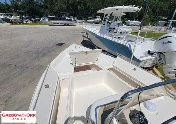 Slide: The Image of 2024 Bulls Bay 2200 boat with open storage compartments at a marina. - 8