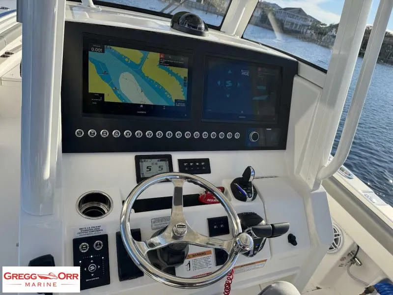 Slide: The Image of 2025 Regulator 28 boat dashboard with navigation screens and steering wheel. - 23
