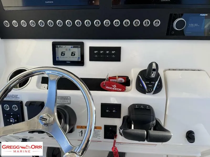 Slide: The Image of Control panel of a 2025 Regulator 28 boat with steering wheel and electronic displays. - 24